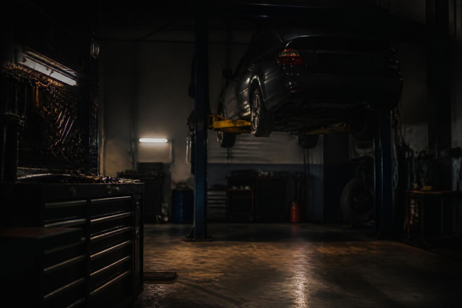 A car raised on the lift inside the Sharpstown Automotive shop